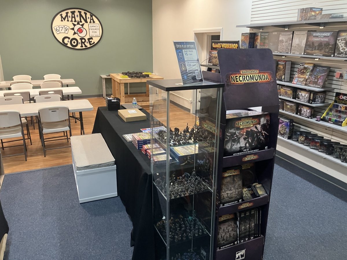 Game tables, miniatures, and Games Workshop shelves inside Mana Core
