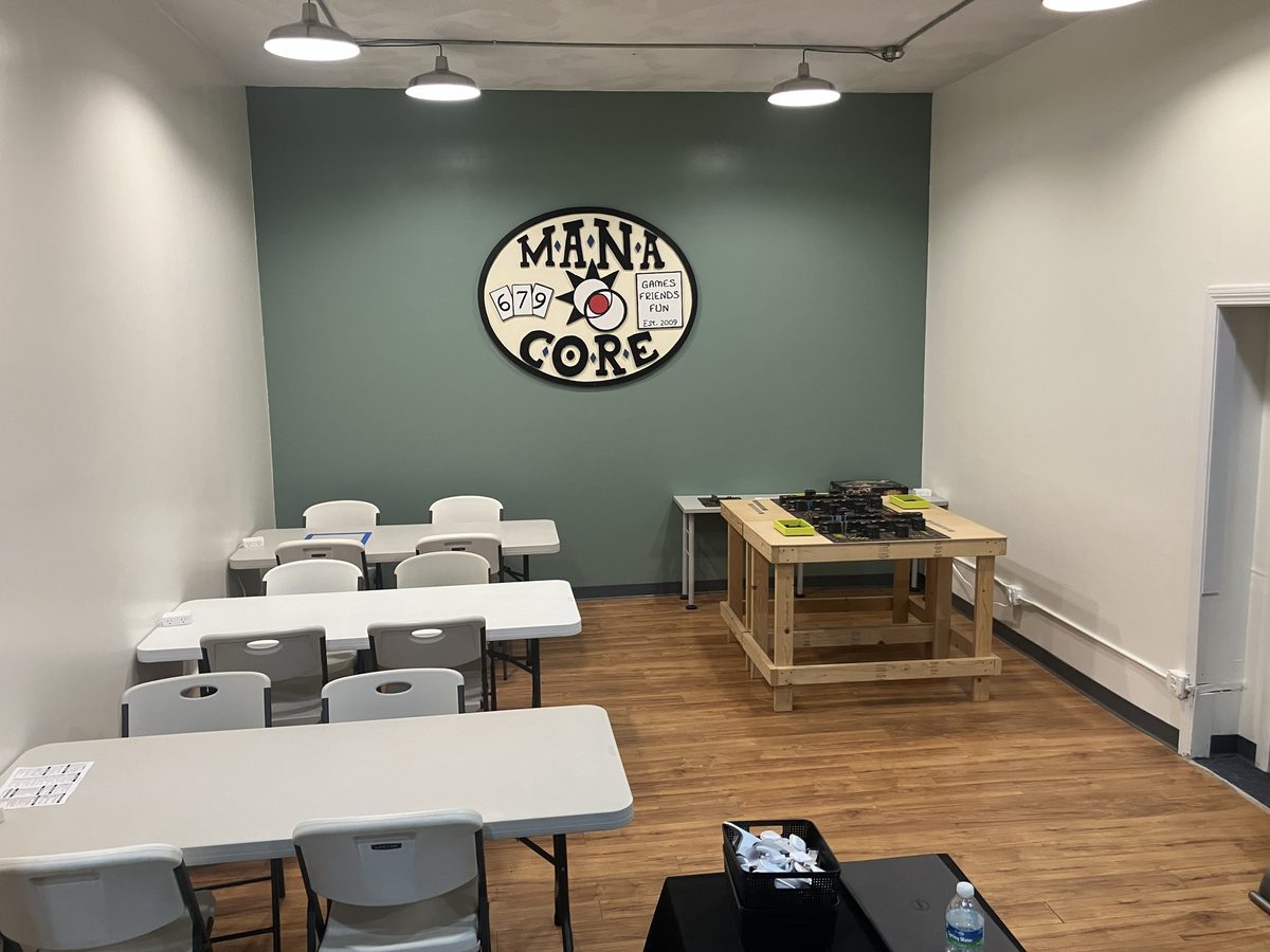 Open-play tables and chairs with Mana Core’s wall sign